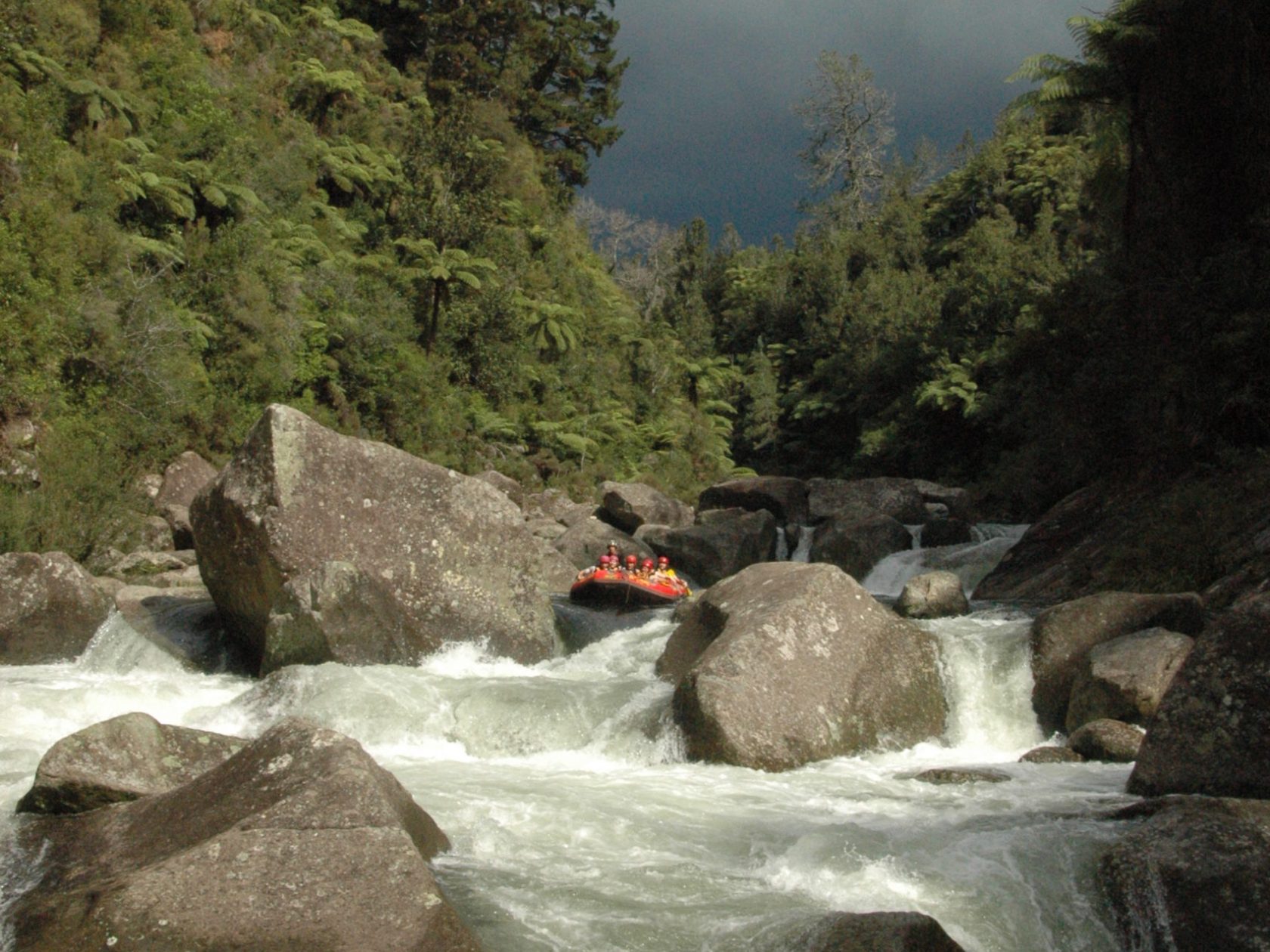 a waterfall with trees on the side of a snow covered mountain