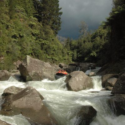 a waterfall with trees on the side of a snow covered mountain