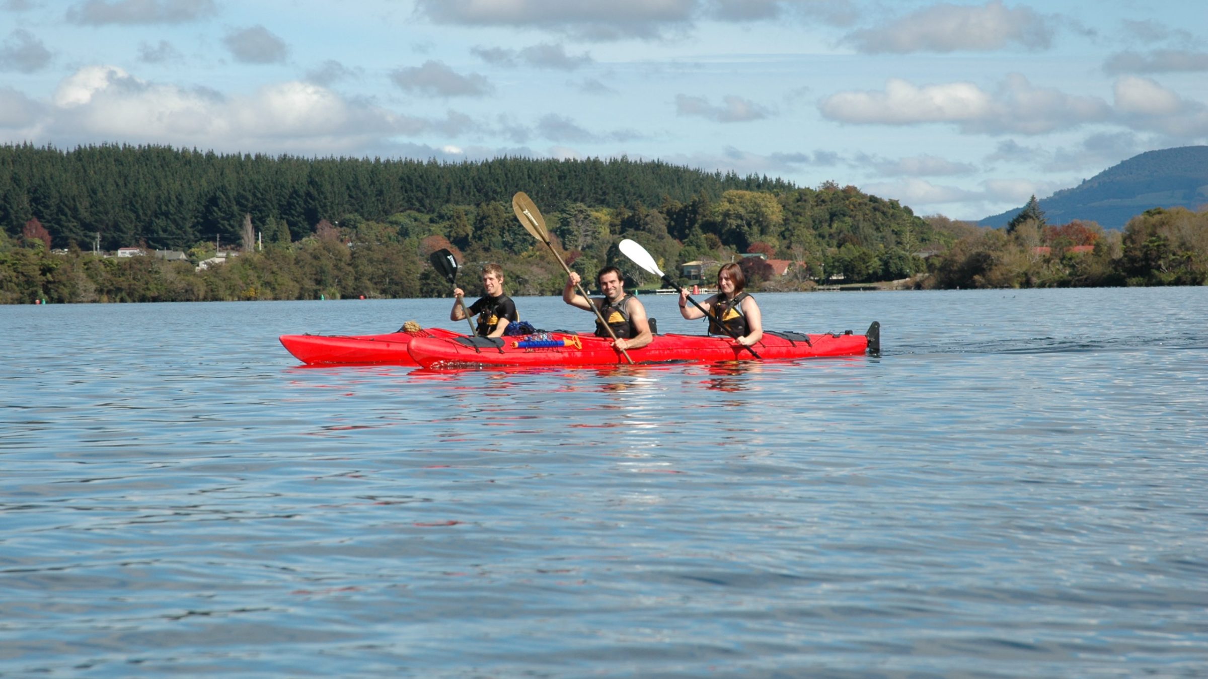 a group of people rowing a boat in a body of water