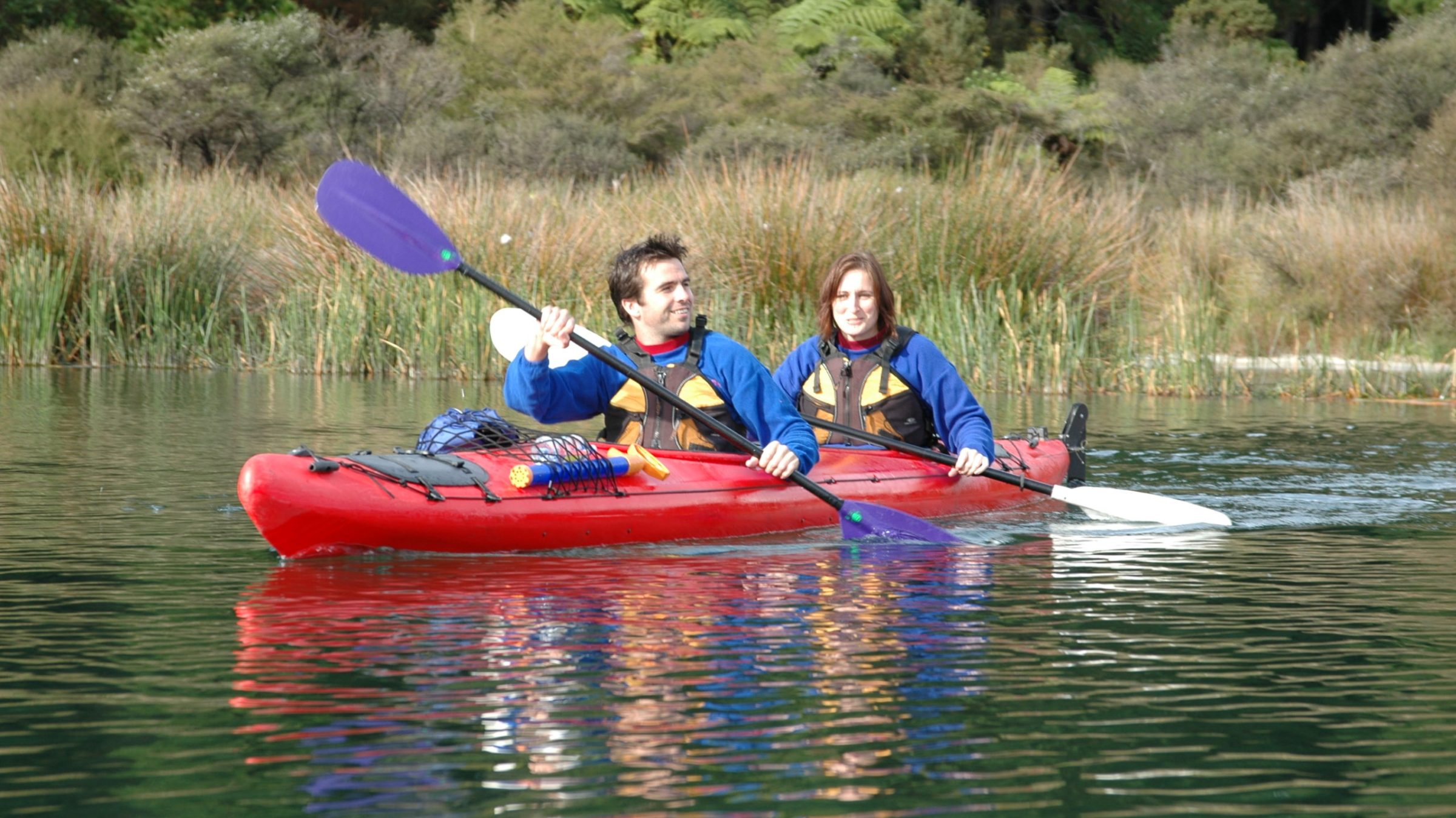 a man riding on the back of a boat in the water