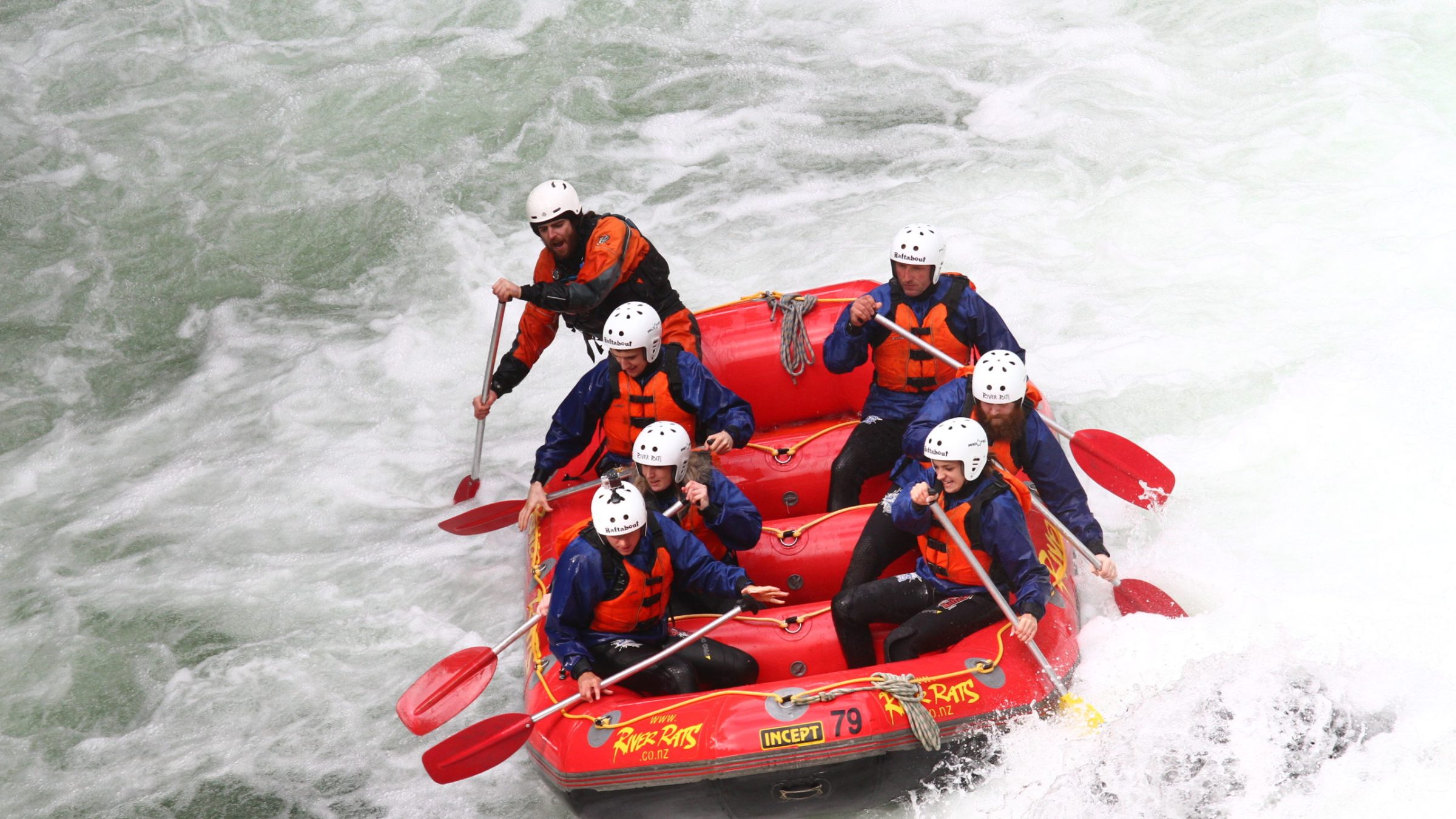 a man riding a wave on a raft in a body of water